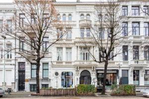 a large white building with trees in front of it at LEO - Antwerp in Antwerp