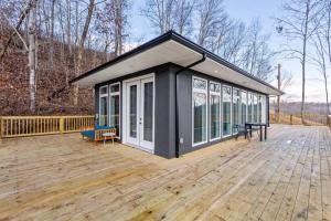 a tiny house with a large deck in the woods at Primrose - Cave Run Lake OR Red River Gorge KY in Wellington