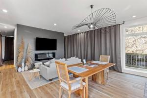 a dining room with a table and a couch and a tv at Primrose - Cave Run Lake OR Red River Gorge KY in Wellington