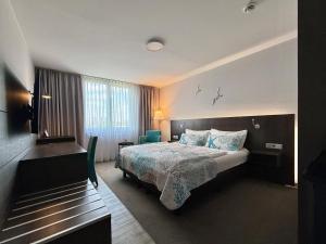 a hotel room with a bed and a window at Elegantes Smart Apartment in Szene-Viertel in Düsseldorf