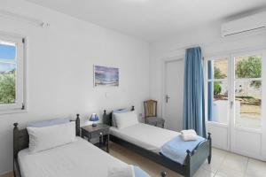Un dormitorio con dos camas y una ventana en Anthoula's Sea View Apartment, en Piso Livadi