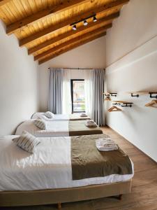 zwei Betten in einem Schlafzimmer mit Holzdecke in der Unterkunft Wenuk Patagonia in San Carlos de Bariloche