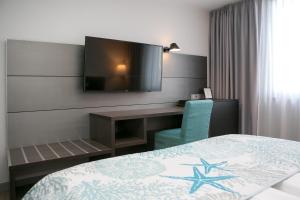 a hotel room with a bed and a desk and a television at Elegantes Smart Apartment in Szene-Viertel in Düsseldorf