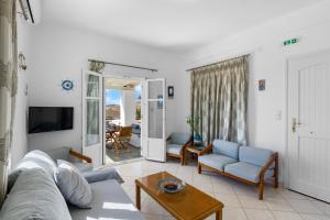 una sala de estar con un sofá y una mesa en Anthoula's Sea View Apartment, en Piso Livadi