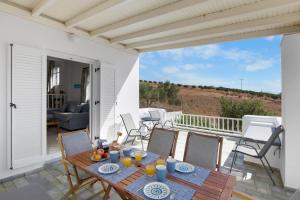 Un patio con una mesa y sillas en un balcón. en Anthoula's Sea View Apartment, en Piso Livadi