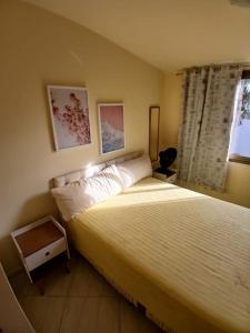 a bedroom with a large bed and a window at Casa Confortável - Cabo Frio in Cabo Frio