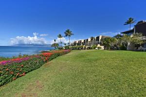 a park next to the water with flowers and buildings at Napili Point C21 · NP C21 OceanFront 2BD Condo w AC Ocean Views in Kahana