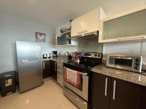 una cocina con refrigerador y estufa horno superior en Peaceful Escazu Getaway with Pool, Wi-Fi & Work Space, en Santa Ana