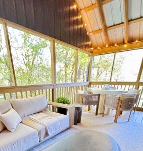 a screened in porch with a couch and a table at Farmhouse at Montaluce Winery-2 Restaurants- Fast WIFI-Free Park-Hike-Weddings in Dahlonega