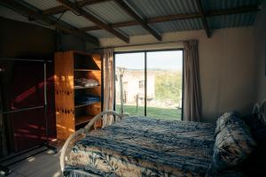 une chambre avec un lit et une grande fenêtre dans l'établissement Self-catering Furnished Holiday Cottage to rent Coffee Bay, à Coffee Bay