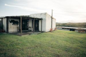 un bâtiment avec une fresque murale représentant des chevaux sur son côté dans l'établissement Self-catering Furnished Holiday Cottage to rent Coffee Bay, à Coffee Bay