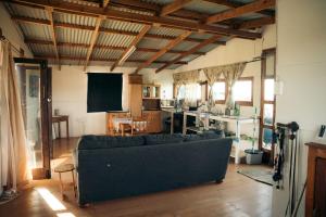 un salon avec un canapé et une télévision dans l'établissement Self-catering Furnished Holiday Cottage to rent Coffee Bay, à Coffee Bay