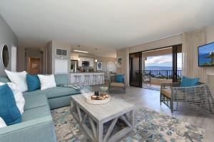a living room with a blue couch and a table at Kaanapali Alii 385 · ALII 385 Corner 2BD OceanFront Dream Vacati in Kaanapali