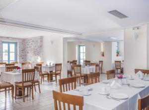 a dining room with white tables and chairs at Thirides Beach Resort in Gythio