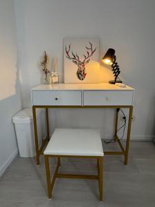 a desk with a lamp and a stool in a room at Appartement chaleureux, proche gare et monuments in Vienne +5 photos
