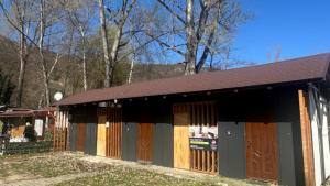 un edificio con puertas de madera y techo marrón en Chalmová CHATA 27, en Bystričany