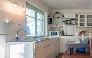 a kitchen with white cabinets and a sink and a window at Awesome Home In Nevidane With Wifi in Neviđane