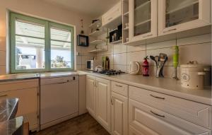 a white kitchen with white cabinets and a window at Awesome Home In Nevidane With Wifi in Neviđane
