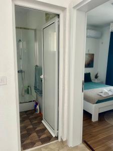 a bathroom with a glass door leading to a bedroom at PrivatHomeUlcinj1 in Ulcinj