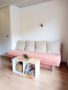 a pink couch in a living room with a table at Chez Cle'Montagne in Ovronnaz