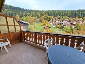 a balcony with a table and chairs and a view at Chez Cle'Montagne in Ovronnaz