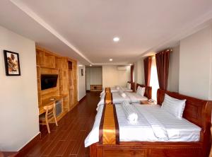 Un dormitorio con dos camas y un escritorio. en Jason Residencia One Hotel, en Phnom Penh