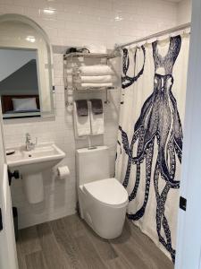 a bathroom with a toilet and a sink and a shower curtain at GREAT ISLAND INN - A Modern Boutique Hotel in New Castle +20 photos