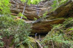 two people standing in front of a rock cave at Beech Timber- 30 Acre Secluded Glamping in RRG in Beattyville