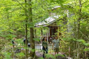 people standing outside of a cabin in the woods at Beech Timber- 30 Acre Secluded Glamping in RRG in Beattyville