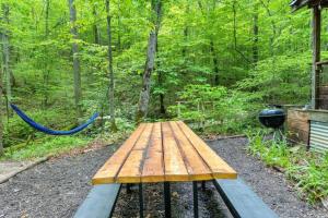 a wooden picnic table in the middle of a forest at Beech Timber- 30 Acre Secluded Glamping in RRG in Beattyville +62 photos