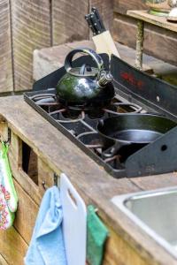a tea kettle sitting on top of a stove at Beech Timber- 30 Acre Secluded Glamping in RRG in Beattyville