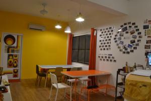 two tables and chairs in a room with yellow walls at Ringo's Foyer in Melaka