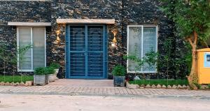 a house with a blue door and two windows at Cozy Villa's in Rawalpindi