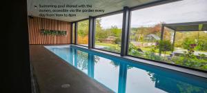 a swimming pool viewed from the window of a house at Maison Activhome in Ospern