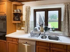 バンプトンにあるDuvale Barnのシンクと窓のあるキッチン