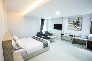 a bedroom with a bed and a living room at parade inn kendari in Pipulu