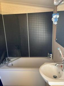 a bathroom with a bath tub and a sink at Caravan by Sea in Morfa Nefyn +8 photos