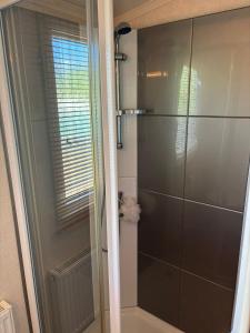 a shower with a glass door in a bathroom at Caravan by Sea in Morfa Nefyn