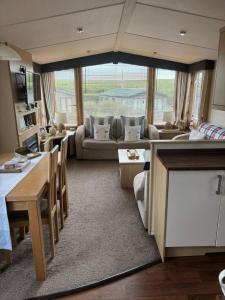a living room with a couch and a table at Caravan by Sea in Morfa Nefyn