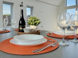 a dining table with a bottle of wine and glasses at Seafields in Sidestrand