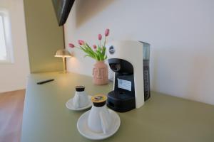 a coffee maker and two cups on a counter at Camera Berlino - La Casa di Carta Affittacamere in Udine