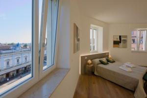 a bedroom with a bed and a large window at Camera Berlino - La Casa di Carta Affittacamere in Udine