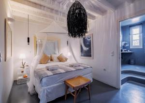 a bedroom with a bed and a chandelier at Manu Mykonos Exclusive Villa Luxury Beachside Stay with Private Pool by Quality Brand Villas in Kalafatis +32 photos