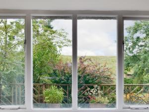an open window with a view of a garden at Elm Cottage in Beckermonds