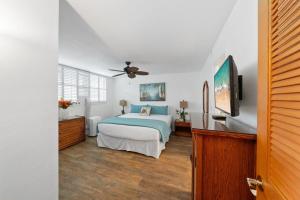 a bedroom with a bed and a flat screen tv at Milowai 302 · MIL 302 Oceanfront 2BD w Ocean Views Whale Watch in Wailuku