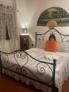 una camera da letto con un letto nero e un cuscino arancione di Toscana, La Terra Del Vino Sharon House per Degustare il Chianti! a Incisa in Valdarno Altre 27 foto