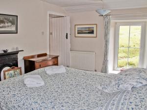 a bedroom with a bed with two towels on it at Elm Cottage in Beckermonds +10 photos