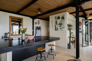 eine Küche mit einer schwarzen Theke und Hockern in der Unterkunft Mar de Uluwatu - Ocean View Villa in Uluwatu + 57 Fotos