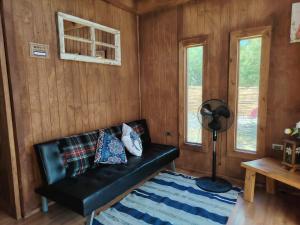 a black leather couch in a room with wooden walls at Casa Puente en Rivadavia in Vicuña +74 photos