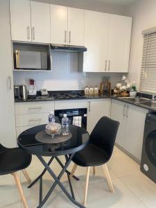 a small kitchen with a table and chairs in it at Kastina Suites at The Fig in Gaborone